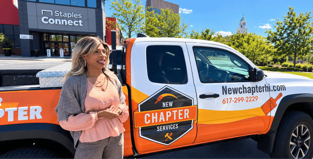 Vicki Gray stands in front of a New Chapter HI branded truck, gazing into the distance.